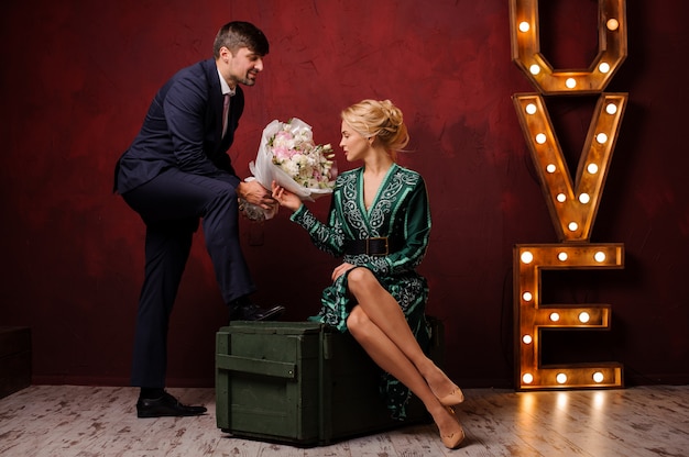 woman in the green dress sitting on the box gets a bouquet her man