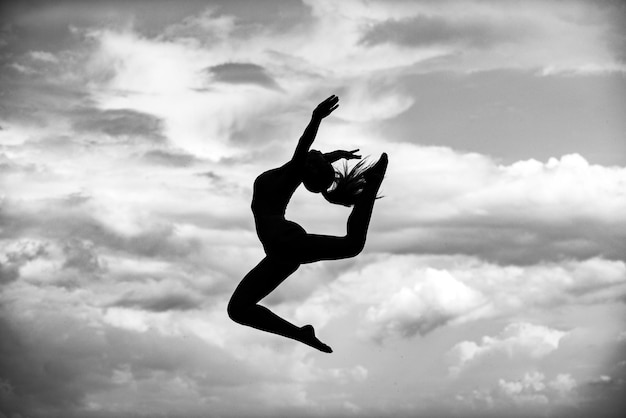 Woman gymnastic silhouette woman gymnast on blue sky background silhouetted gymnast doing the splits