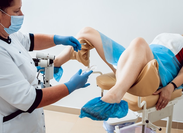 Woman in gynecological chair during gynecological check up with her doctor.