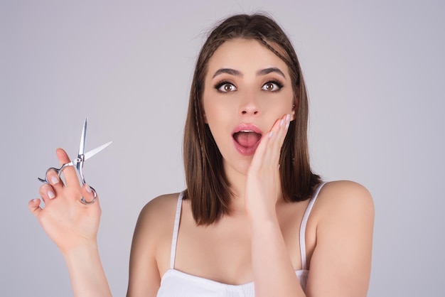 Woman hairdresser cutting hair with a scissors