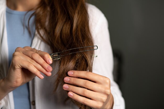 Woman hairdresser holding hair clip at beauty salon. Closeup shot