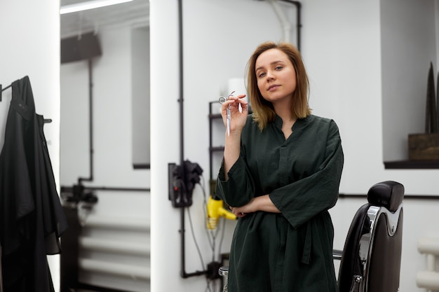 Woman hairdresser standing in barbershop