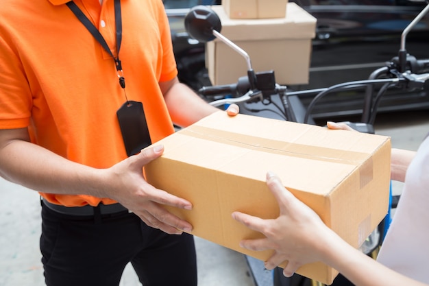 Woman hand accepting a delivery of boxes from deliveryman, Deliver goods by motorcycle service, Fast and Free Transport