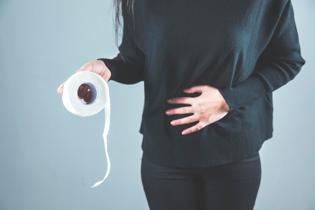 Woman hand in ache belly with hand toilet paper