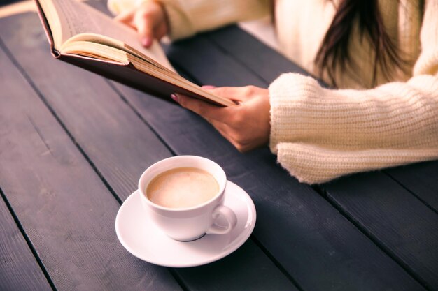 Woman hand book with coffee