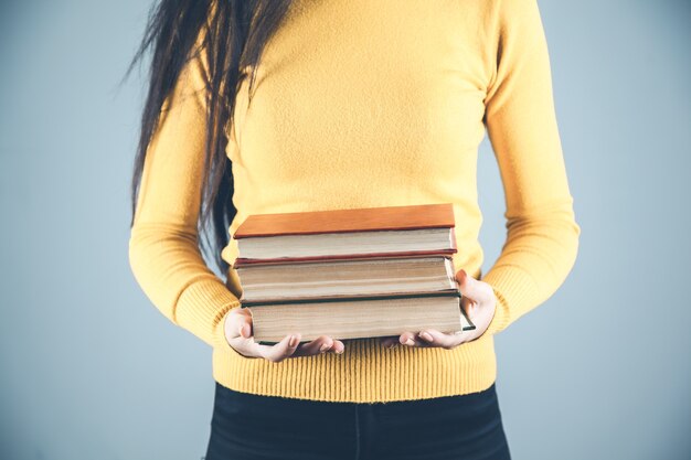 Foto libri di mano della donna su sfondo grigio