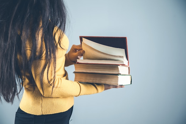 Женщина руки книги на сером фоне
