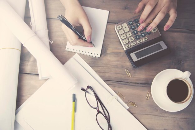 Woman hand calculator and pen on working table