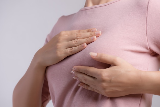 Woman hand checking lumps on her breast cancer