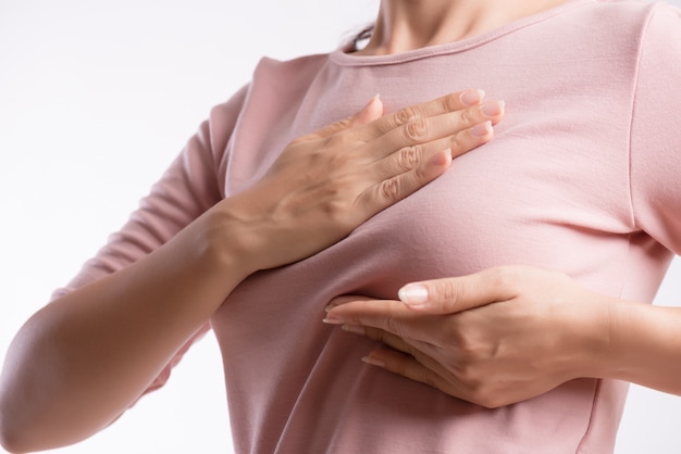 Woman hand checking lumps on her breast for signs of breast cancer