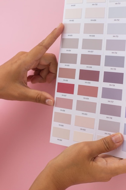 샘플 팔레트 근접 촬영에서 장밋빛 또는 분홍색 그림 색상을 선택하는 여자 손