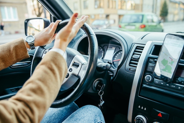 写真 女性の手は運転をクローズアップします。渋滞に巻き込まれました。電話でのナビゲーション。ライフスタイル