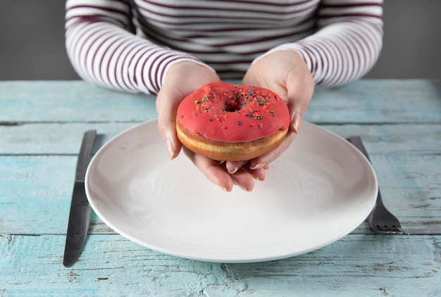 Woman hand donut in plate