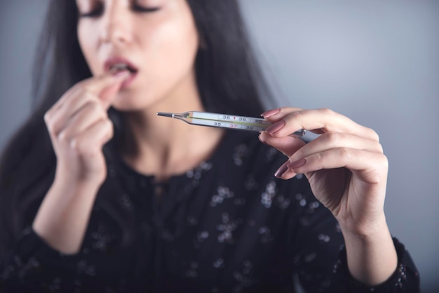 Woman hand drug and thermometer