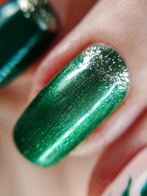 Woman hand finger green silver glitter shimmer manicure gel nail polish swatch design beauty fashion macro photo