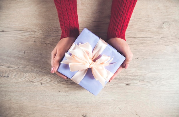 Woman hand gift box on desk