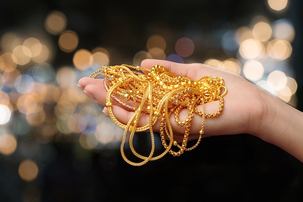 Foto donna mano tenere gioielli braccialetto d'oro e collana