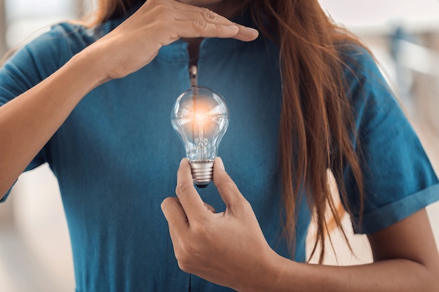 Foto la mano della donna tiene la creatività della lampadina