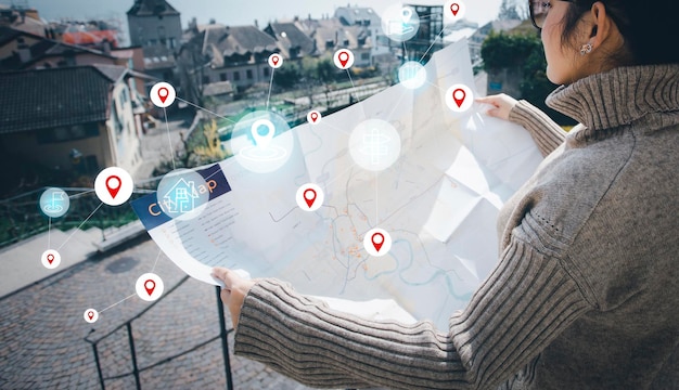 Woman hand hold map city for travel and model map with location
point gps app icon travel maps and find places in the online system
all screen graphics are generatedsearching for travel goals