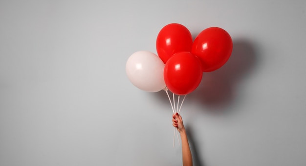 Aerostato rosso e bianco della stretta della mano della donna