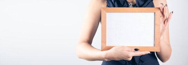 Woman hand holding blank photo frame.
