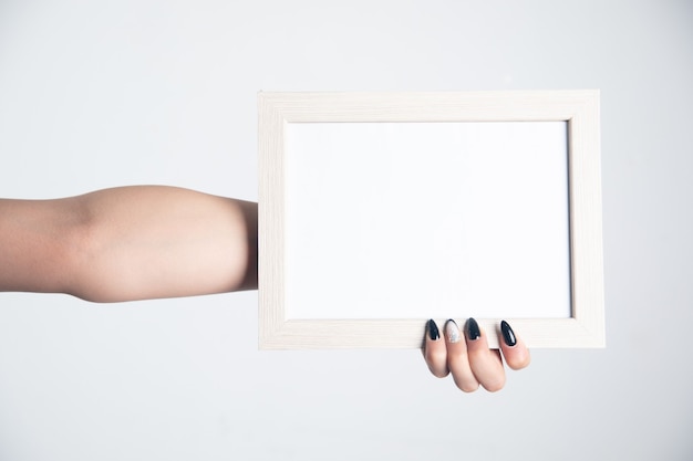 Photo woman hand holding blank photo frame.