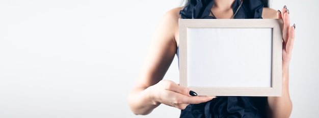 Woman hand holding blank photo frame.