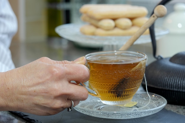 お茶のカップを持つ女性の手