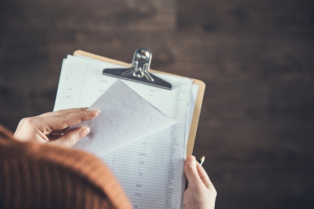 Woman hand holding document on the dark