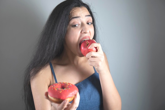 Woman hand holding Donut and apple