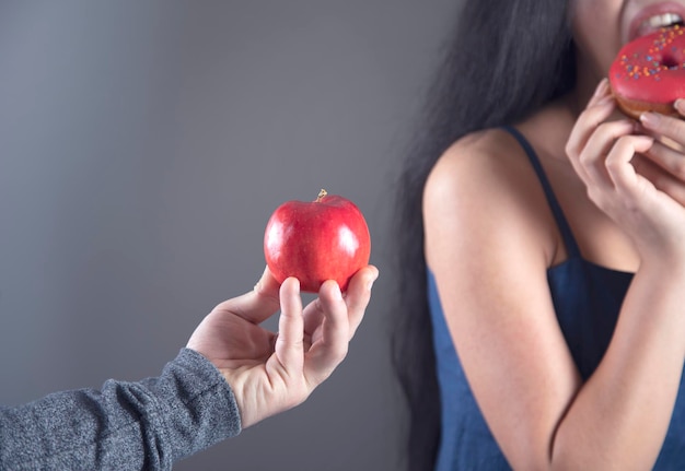 Woman hand holding Donut and apple