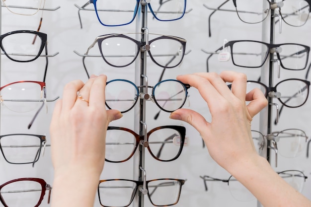 Woman hand holding eyeglasses in optics shop