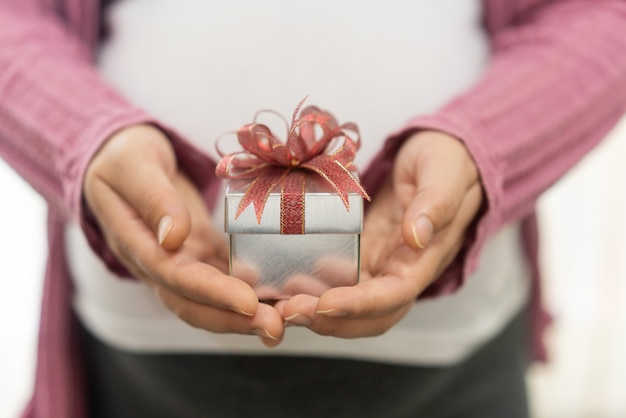 Woman hand holding gift box of christmas present.