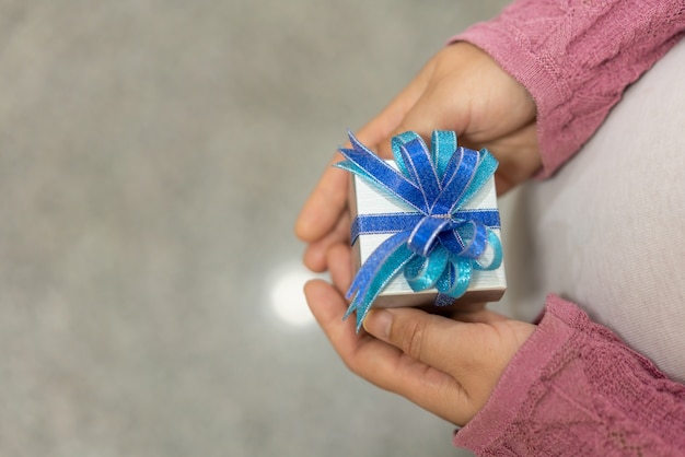 Woman hand holding gift box of christmas present.