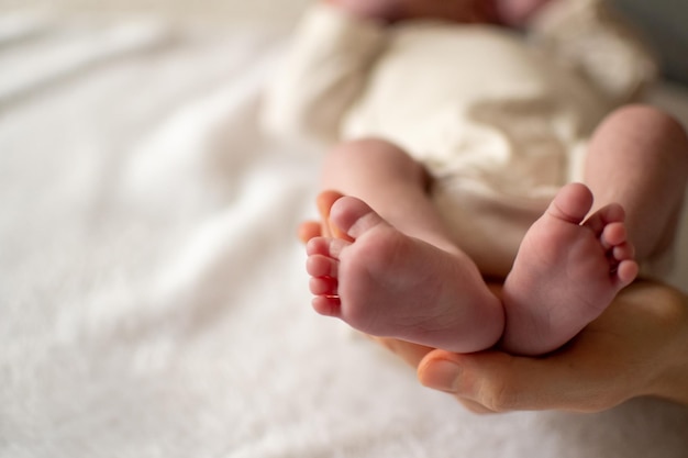 Woman hand holding her baby feet