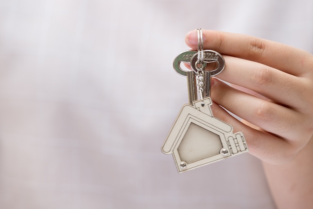 家の鍵を持つ女性の手。不動産事業のコンセプトです。