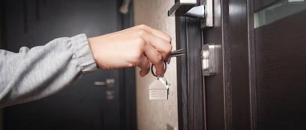 Woman hand holding house key at home