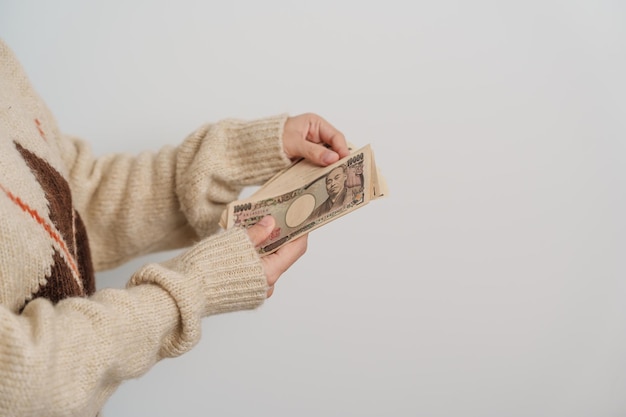 Photo woman hand holding japanese yen banknote stack thousand yen money japan cash tax recession economy inflation investment finance and shopping payment concepts