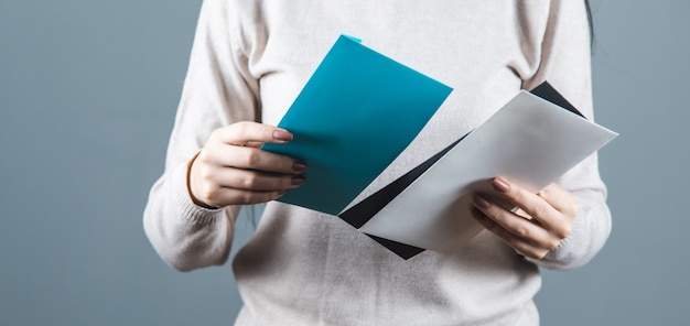 Foto lettere della holding della mano della donna sui precedenti grigi