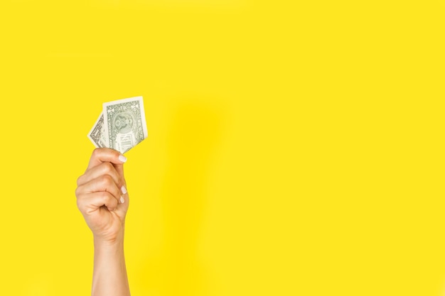 Woman hand holding a one dollar bill on a white background with copy space