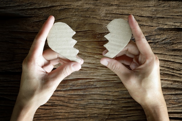 Photo woman hand holding paper cut broken heart