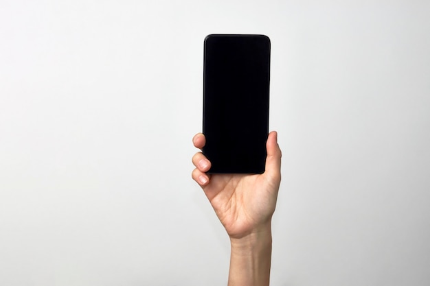 Woman hand holding phone on white background with copy space