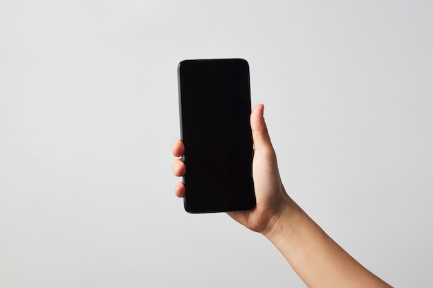 Woman hand holding phone on white background with copy space