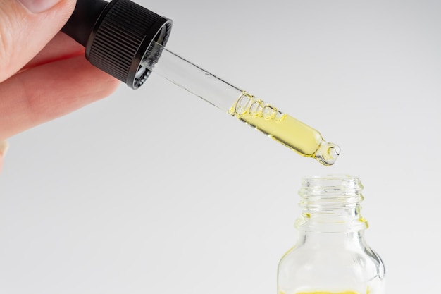woman hand holding serum glass bottle with pipette ascorbic acid resveratrol caffeine solution hydration of skin and eye contour skin care routine concept