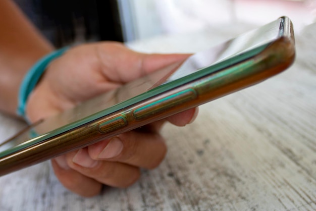 Photo woman hand holding smartphone on her desk close up of hands woman using her cell phone indoor