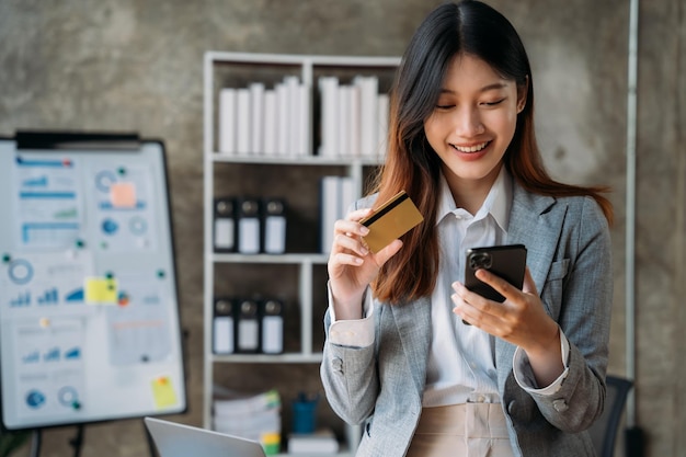 Woman hand holding smartphone and using credit card for online shoppingOnline shopping concept