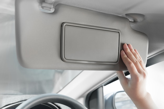 woman hand holding sun visor interior inside car