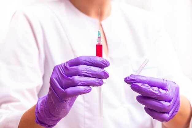 Woman hand holding syringe and ampule