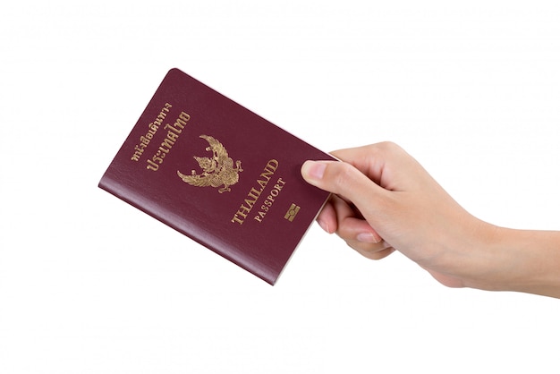 Фото Рука женщины держа тайский паспорт изолированный на белизне