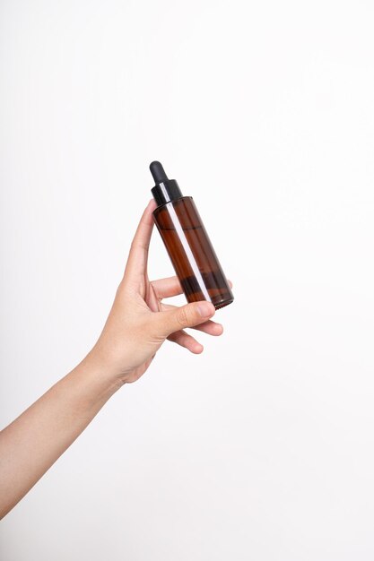 woman hand holding unbranded bottle of serum skin care and cosmetic concept serum mockup